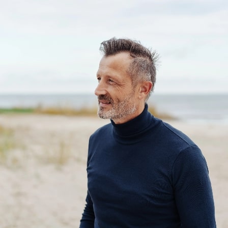 Middle aged man smiling at beach